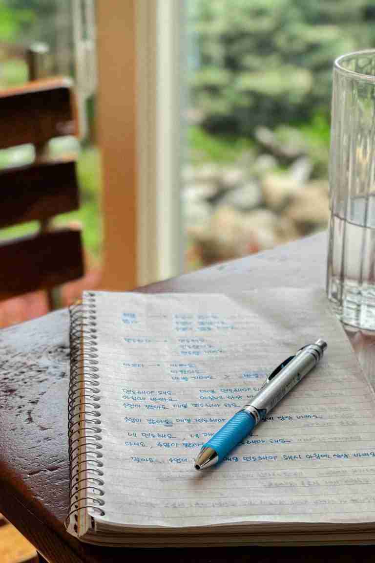 Korean study notes with a pen on top on a table