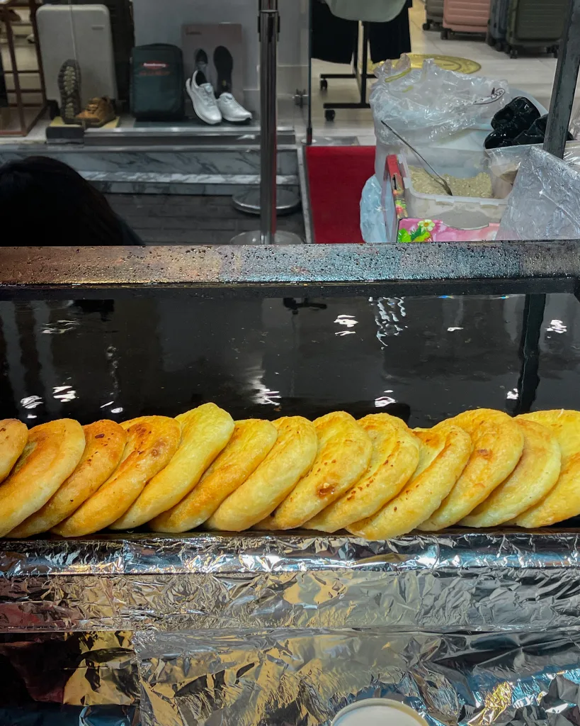 Rows of golden hotteok, crispy and hot off the griddle, at a bustling Seoul street food stall. These sweet pancakes are a street food favorite and a winter must-eat when in Seoul.