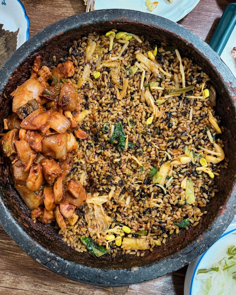 Grilled hagfish cooks on a sizzling pan alongside vegetables and seasoning at a restaurant in Seomyeon Food Street. This spicy local specialty is one of Busan's more adventurous dishes to try.