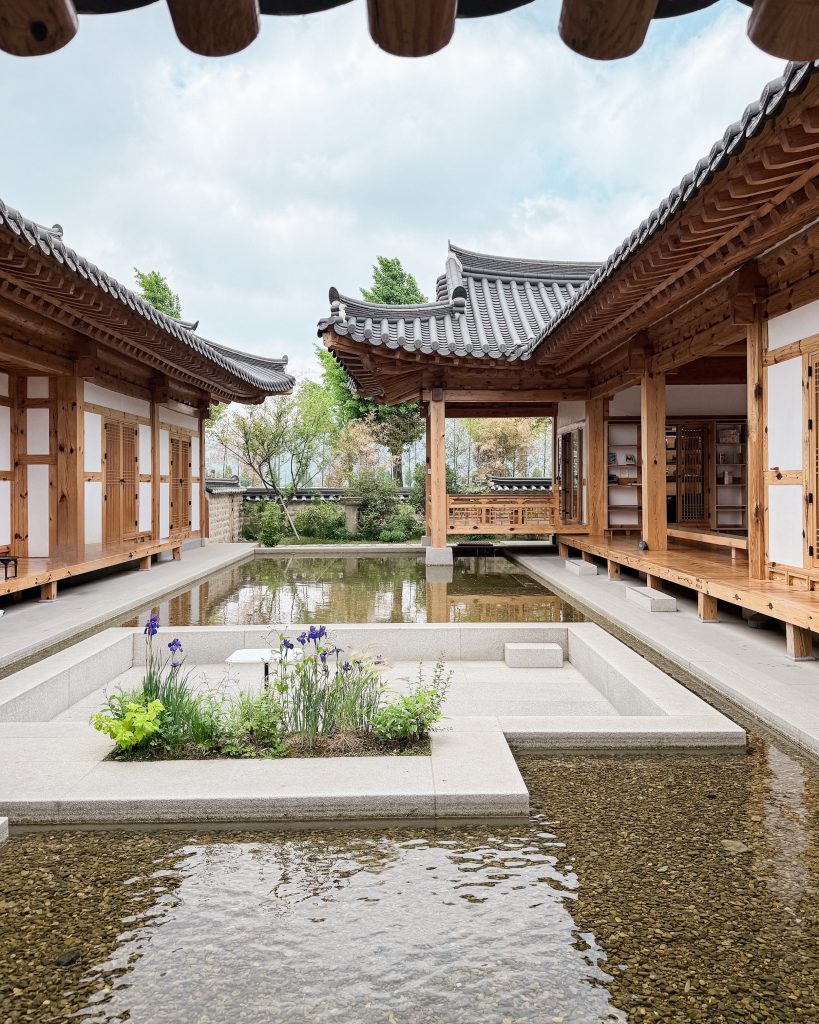 Traditional hanok buildings surround a peaceful reflecting pond in the courtyard of Terarosa Cafรฉ in Gyeongju. The spacious cafรฉ is a relaxing afternoon stop for coffee and tiramisu after a good meal at Jinmi SIkdang.