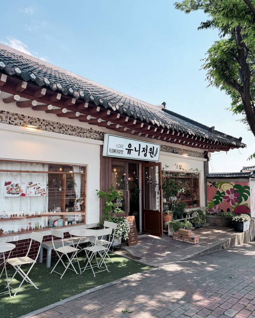 Exterior of Cafe Yunigarden near Bulguksa Temple with traditional rooflines, outdoor seating, flower displays, and a welcoming storefront. The peaceful setting makes it an ideal place to relax after sightseeing.