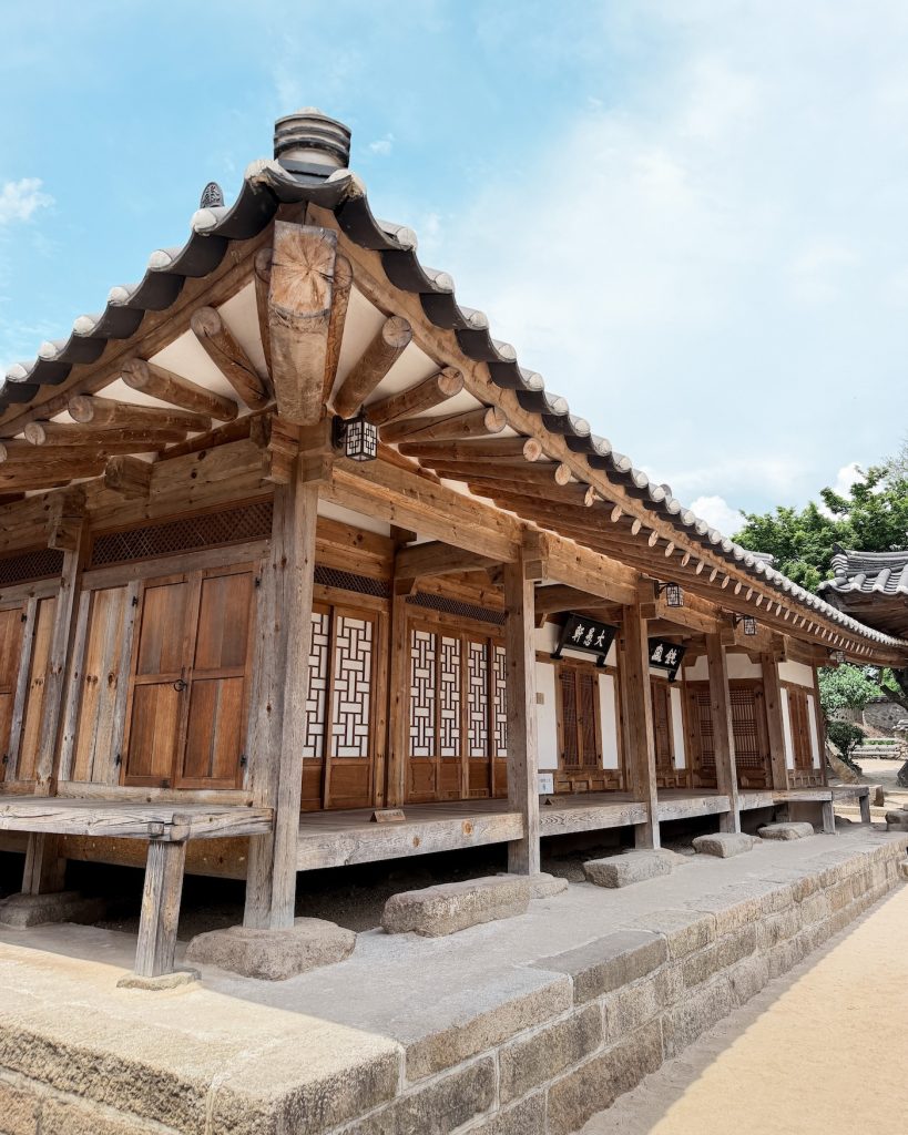 Traditional wooden hanok buildings with tiled roofs at the historic Choi family home in Gyochon Traditional Village. The well-preserved residence offers a glimpse into the lifestyle of an influential Joseon-era aristocratic family.