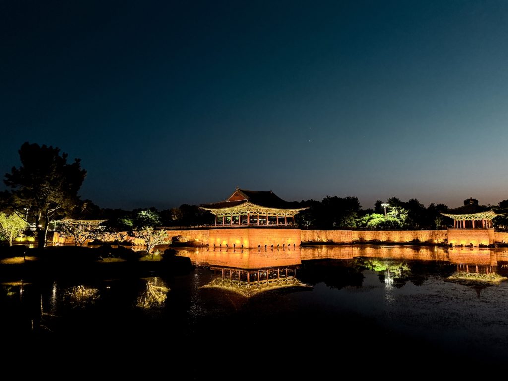 Donggung Palace and Wolji Pond illuminated at night, with the historic pavilions reflected in the calm water.