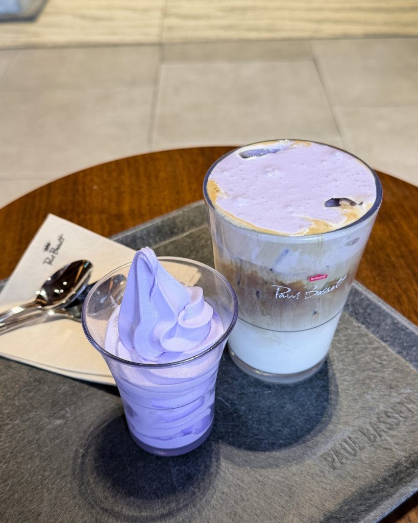 Lavender soft serve and a lavender latte from Paul Bassett's seasonal menu served on a tray inside the hanok cafรฉ. The vibrant purple desserts highlight the cafรฉ's rotating specialty drinks and treats.