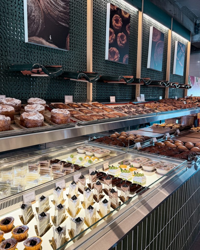 A bakery display at Cafรฉ Aden filled with fresh pastries, cakes, tarts, and desserts behind a glass case. The wide selection makes it a popular stop for coffee and baked treats in Gyeongju.