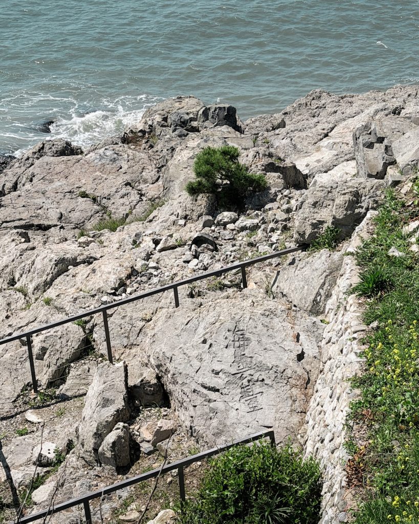 Ancient Chinese characters reading "Haeundae" are carved into a large seaside rock overlooking the water at Dongbaekseom. The historic inscription commemorates the scholar Choi Chi Won, who gave Haeundae its name over a thousand years ago.